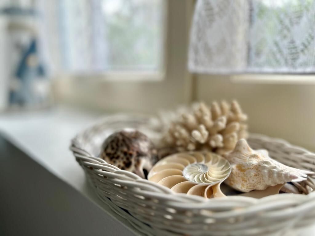 A wicker basket containing decorative items on a windowsill.