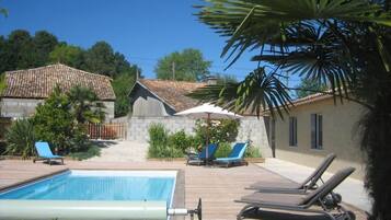 Una piscina techada, una piscina al aire libre de temporada, sombrillas