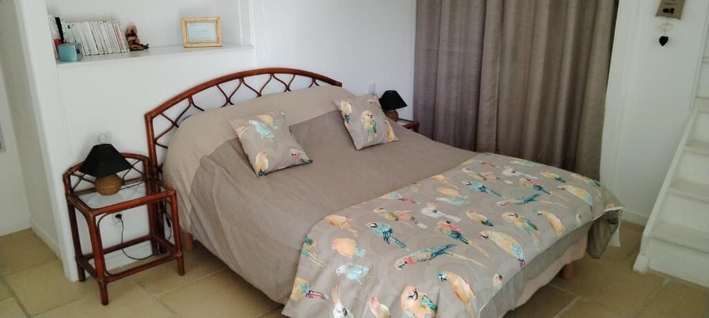 A bedroom with a bed, pillows, a bedside table, and a nightstand.
