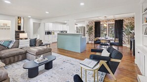 Ein modernes Wohnzimmer mit einer Sofagarnitur, einem Couchtisch und einem Essbereich mit Tisch und Stühlen.