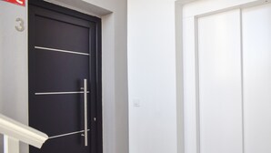 Eine schwarze Tür mit Griff und eine weiße Tür mit schlichtem Design.