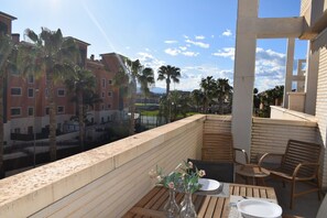 A balcony with a table set for dining, overlooking a cityscape with palm trees and buildings. - Ap2107 in Denia With 2 Bedrooms and 1 Bathrooms (Denia)