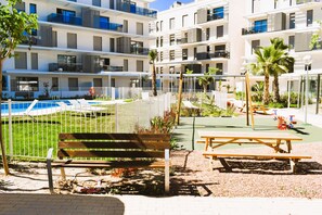 A courtyard with a pool, benches, and playground equipment. - Ap2242 in Denia With 2 Bedrooms and 2 Bathrooms (Denia)