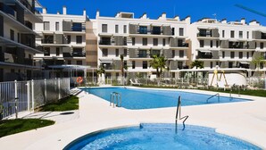 A modern hotel with a swimming pool, multiple balconies, and a clear blue sky. - Ap2242 in Denia With 2 Bedrooms and 2 Bathrooms (Denia)