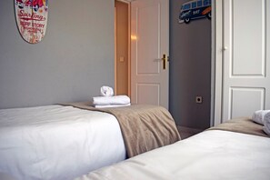 Habitación de hotel con dos camas, una puerta y un adorno en la pared.
