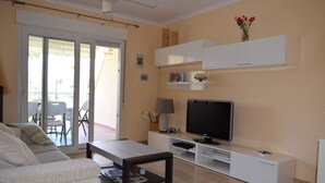 A living room with a sofa, coffee table, TV, and a white entertainment unit. - Ap2215 in Denia With 2 Bedrooms and 2 Bathrooms (Denia)