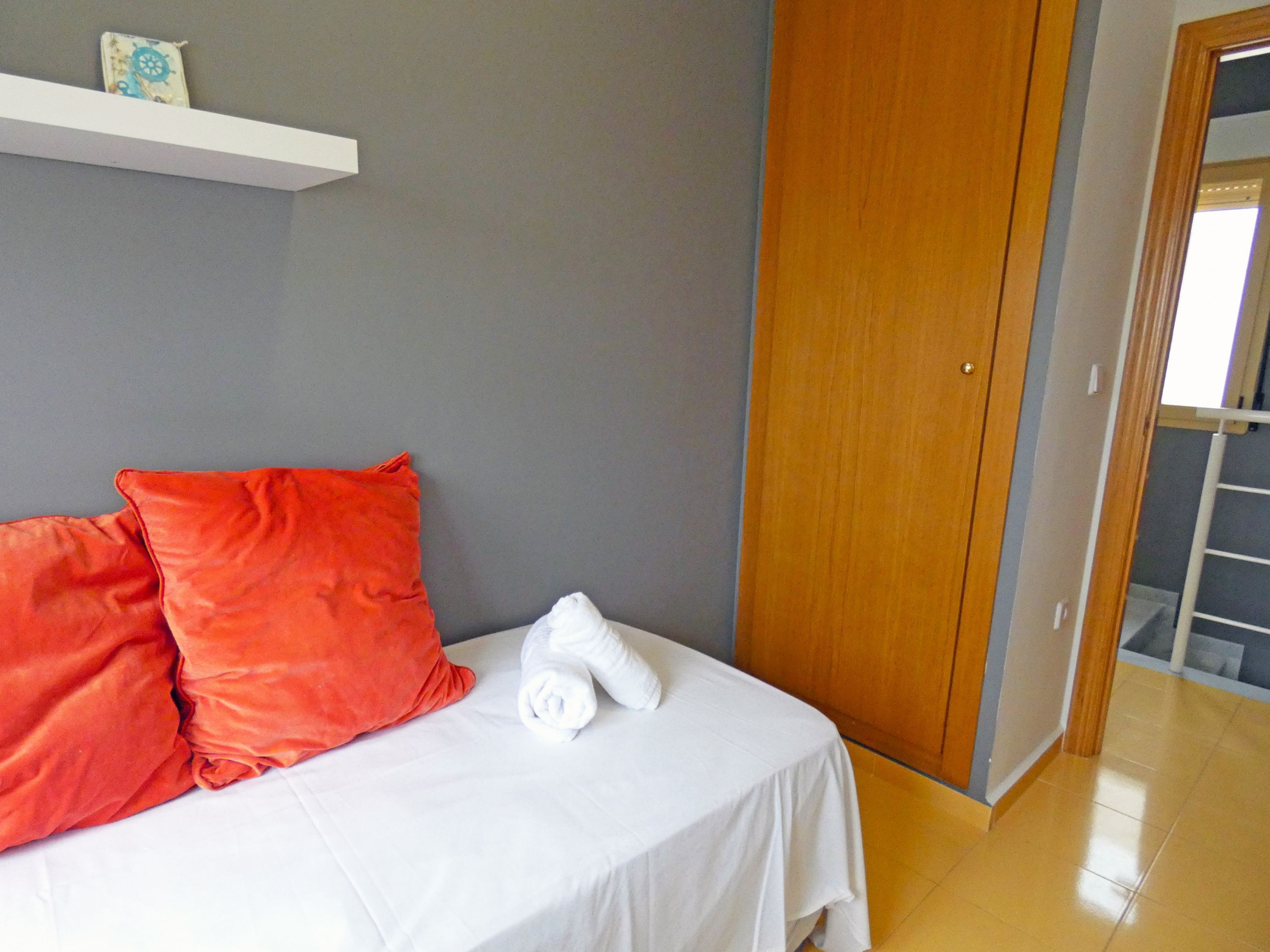 Ein Hotelzimmer mit einem Bett, einem Holzschrank und einer weißen Wand.