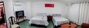 A hotel room with two beds, a TV, a red artwork, and a window with curtains. - Casa Ángel (Morelia)