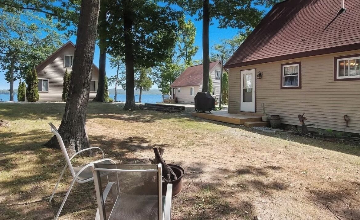 Un chalet au bord du lac, doté d’une terrasse, d’un barbecue et d’une chaise.