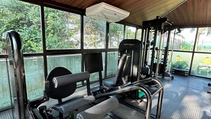 An outdoor gym with exercise equipment, a covered area, and a view of greenery. - Flat Premium Vista Mar - Praia de Tabatinga (Conde)