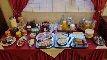 Un bufé de desayuno con diversas opciones de comida, salsas y bebidas.