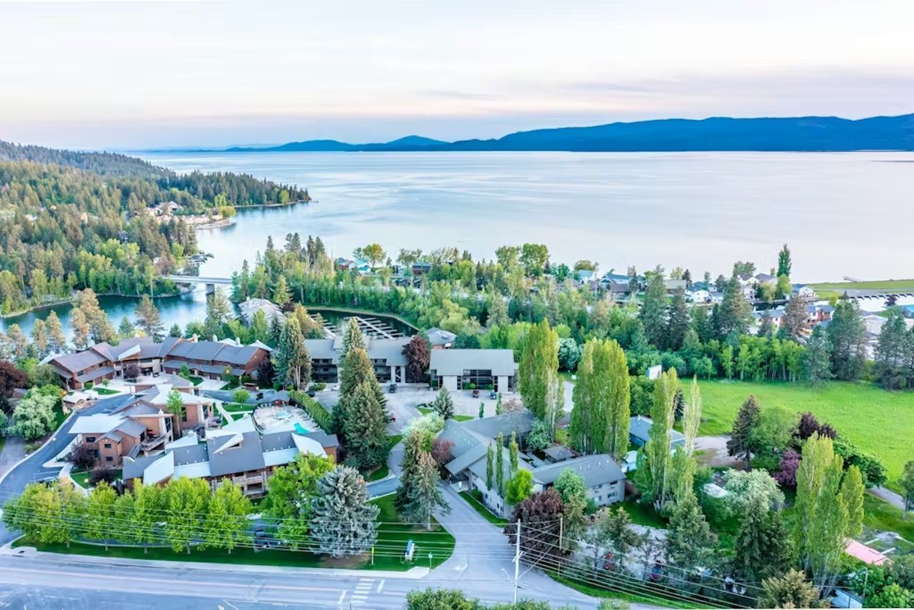Un quartiere residenziale con un lago, case e un ponte.