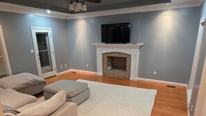 Una sala de estar con un sofá modular, una chimenea y un televisor de pantalla plana montado arriba.