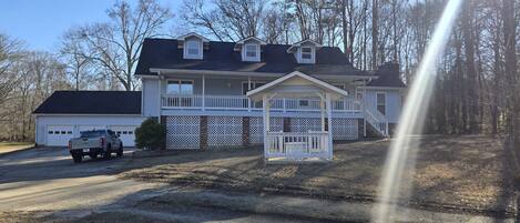 A two-story house with a garage, a covered porch, and a driveway.