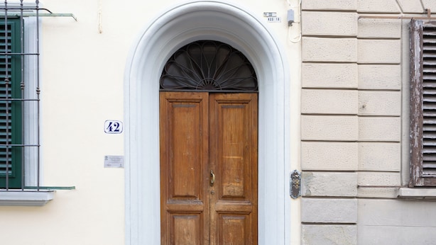 A double wooden door with a white archway, a number '42' sign, and a window with green shutters. - Ruote 42 by Wynwood House (Florence)