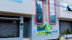 Un edificio moderno con un cartel llamativo que dice "Q'HAWAQ".