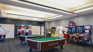 Un espacio de esparcimiento con mesas de billar y juegos de arcade.