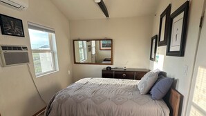 Ein Schlafzimmer mit Bett, Schminktisch, Spiegel und Teppich.