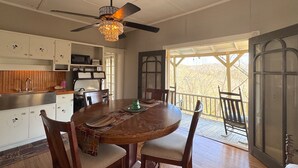 A dining area with a wooden table, chairs, and a ceiling fan. - Wishing Star Townhouse on Spring Street (Eureka Springs)