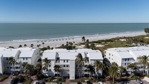 A beachfront hotel with multiple white buildings, palm trees, and a view of the ocean. - Beach Villa 2535- Executive Penthouse Residence on Captiva Island (Captiva)