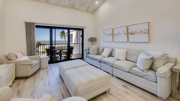 A spacious living room with a large sofa, a coffee table, and a balcony with a view. - Beach Villa 2535- Executive Penthouse Residence on Captiva Island (Captiva)