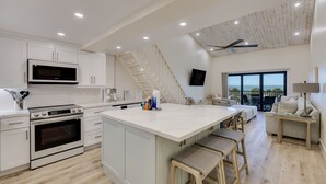 A modern kitchen with white cabinetry, a large island, and a built-in oven. - Beach Villa 2535- Executive Penthouse Residence on Captiva Island (Captiva)