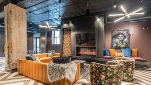 Ein moderner Lounge-Bereich mit Kamin, Sitzgelegenheiten und einer großen Wandmalerei.