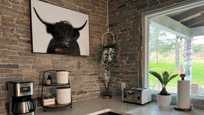 A kitchen with a brick wall, a coffee maker, a toaster, and a potted plant. - 10 acres property great for outside activities its great place to make memories (Walton)