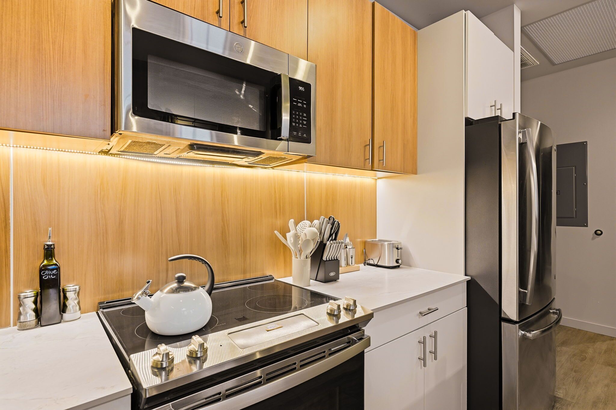 Una cucina moderna con elettrodomestici in acciaio inossidabile, mobili in legno e forno integrato.