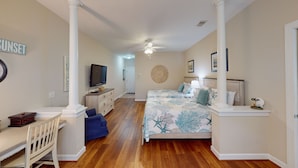 A bedroom with a bed, a desk, a television, and a ceiling fan. - Champions Unit 3707 (Sunset Beach)