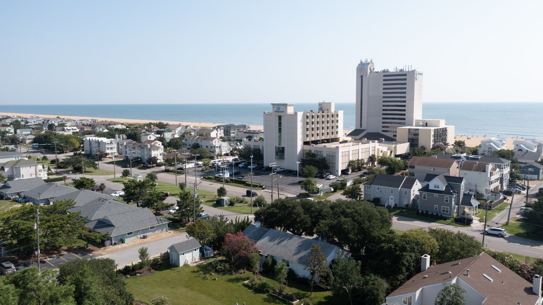 A coastal residential area with a mix of single-family homes and commercial buildings, including a prominent hotel with a modern design.