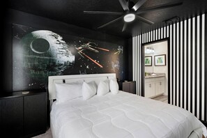 A modern bedroom with a bed, a ceiling fan, and a wall mural of a space scene. - Cdw9161 (Davenport)