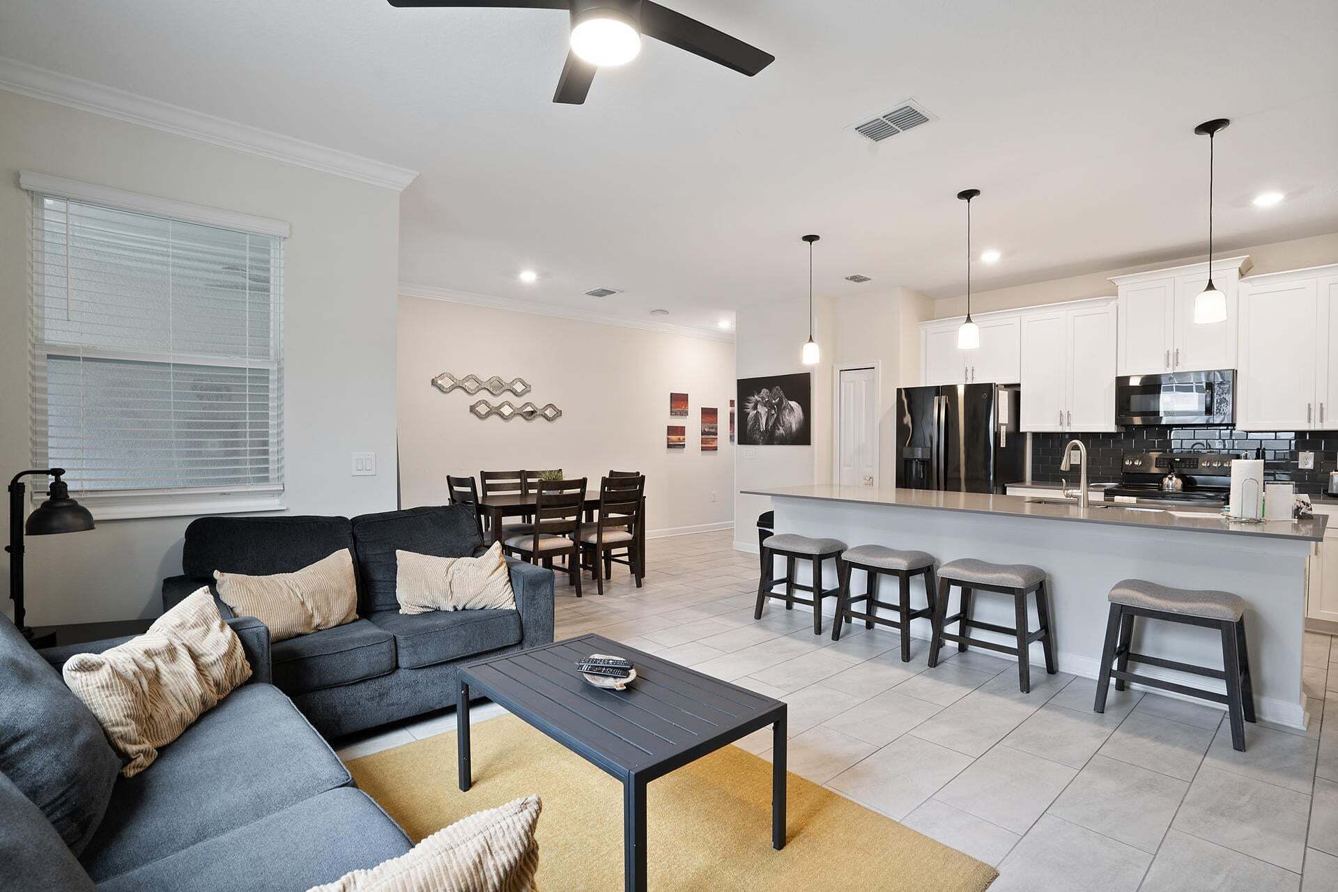 A modern living room with a sofa, coffee table, and dining area.