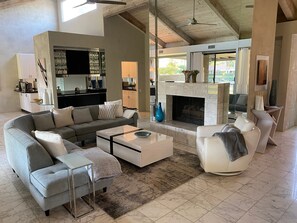 A modern living room with a sofa, coffee table, and fireplace. - Cloud Nine (Rancho Mirage)