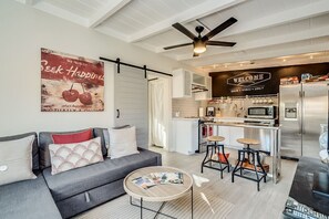 A modern kitchen with a bar area, a dining table, and a sofa in a living room. - Chic Duplex in Tucson 1 of 2 (Tucson)