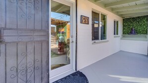 A building with a white exterior, a numbered door, and a covered porch area. - Chic Duplex in Tucson 1 of 2 (Tucson)