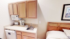 A compact kitchenette with a microwave, toaster, coffee maker, and a small sink. - Club Villas Unit 25A - Lower Level (Sunset Beach)