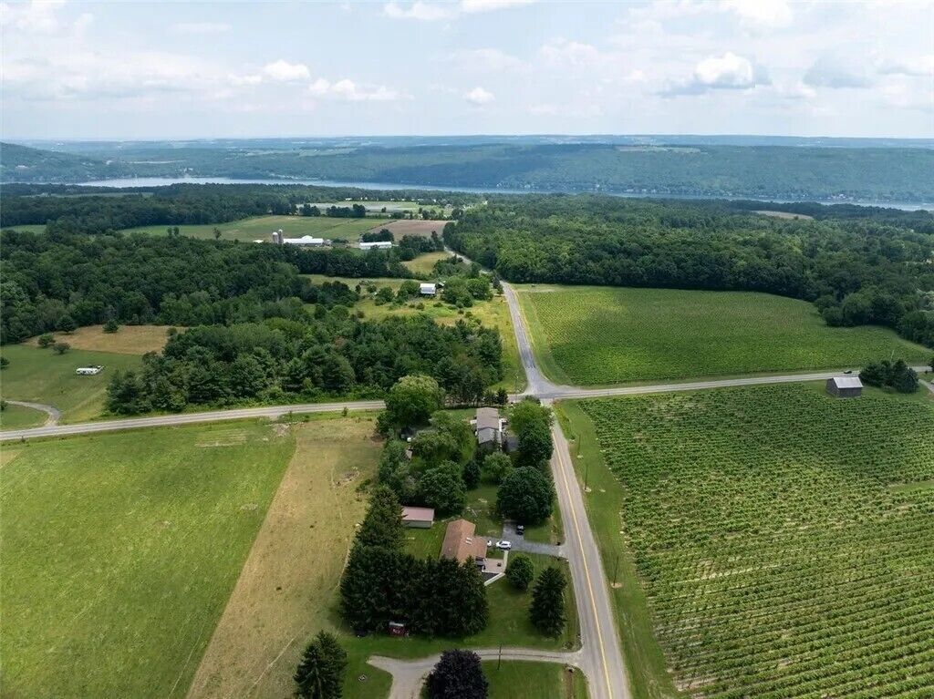 An aerial view of a rural landscape with fields, a road, and scattered buildings.