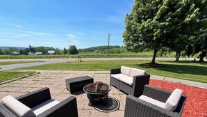 An outdoor seating area with wicker furniture and a fire pit. - Secluded Finger Lakes 3BR Retreat Near Keuka Lake with Vineyard Views (Branchport)