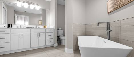 A modern bathroom with a freestanding bathtub, white cabinetry, and a large mirror.