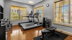 Una palestra con tapis roulant, una panca e macchinari per pesi.