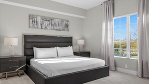 Una camera da letto moderna con un letto grande, due comodini, una ventola a soffitto e una finestra con tende.