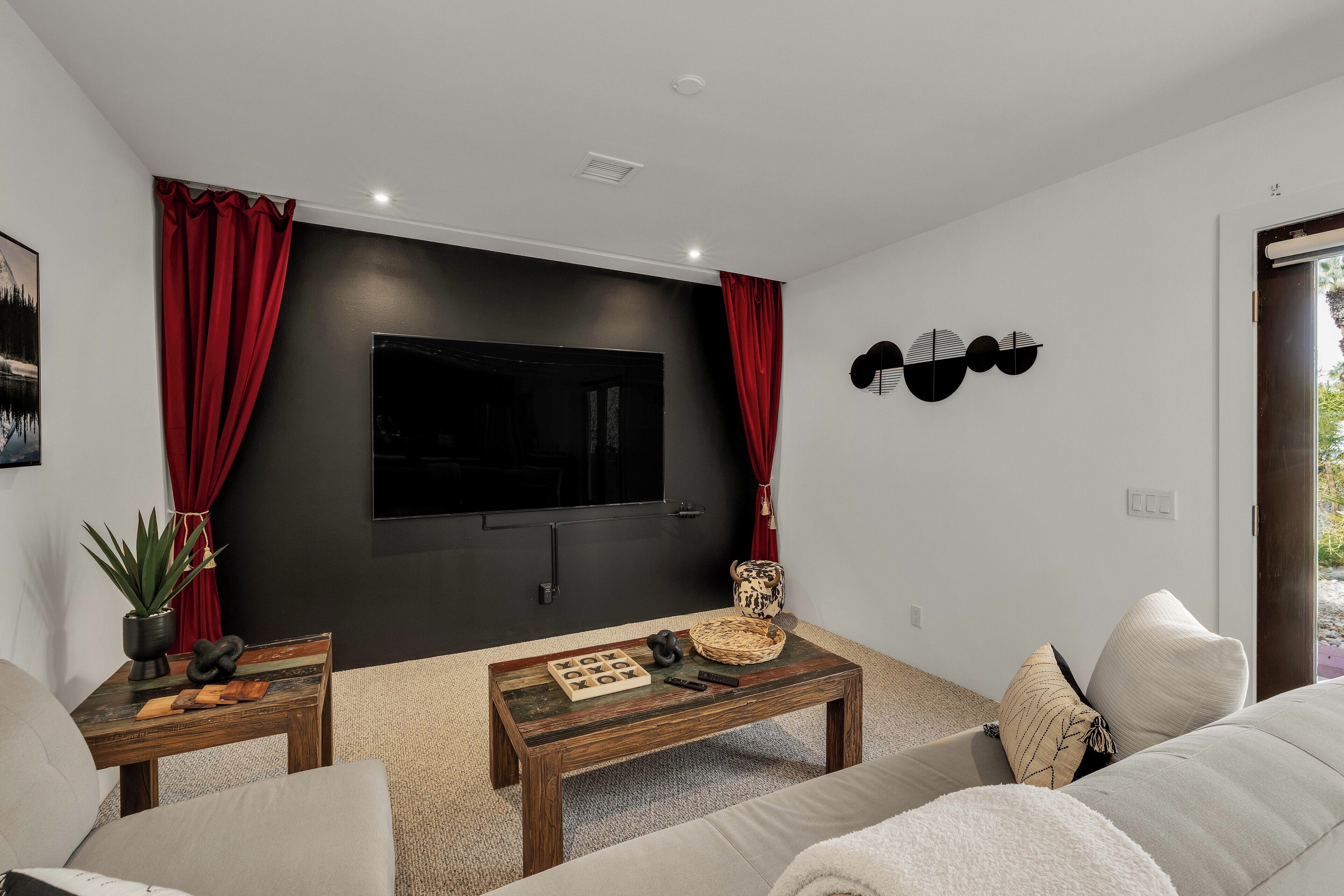 A modern living room with a flat-screen TV, a coffee table, and a sofa.