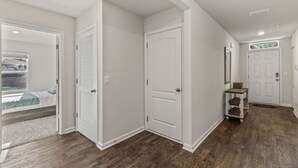 Un corridoio con un letto, un armadio e una porta che dà su un'altra stanza.