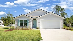 Una casa a un piano con garage, ingresso principale e un piccolo portico.