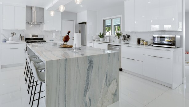 Een moderne keuken met witte kasten, een marmeren eiland en roestvrijstalen apparatuur.