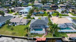 A residential area with houses, a swimming pool, and a dock. - Life's Porpoises - 29 Coconut Ct (Palm Coast)