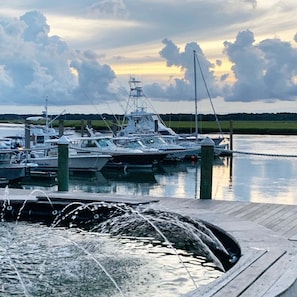 A marina with boats docked, calm water, and a dock with a water feature. - 2109 Landfall Way (Seabrook Island)