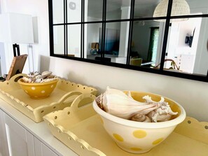Una encimera de cocina con dos cuencos amarillos con lunares que contienen champiñones, una lámpara blanca y una ventana con vistas al interior.
