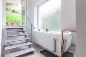 A staircase leading to a landing with a view of a garden. - nJoy! Worker Apartment Oberboihingen | Balcony (Oberboihingen)